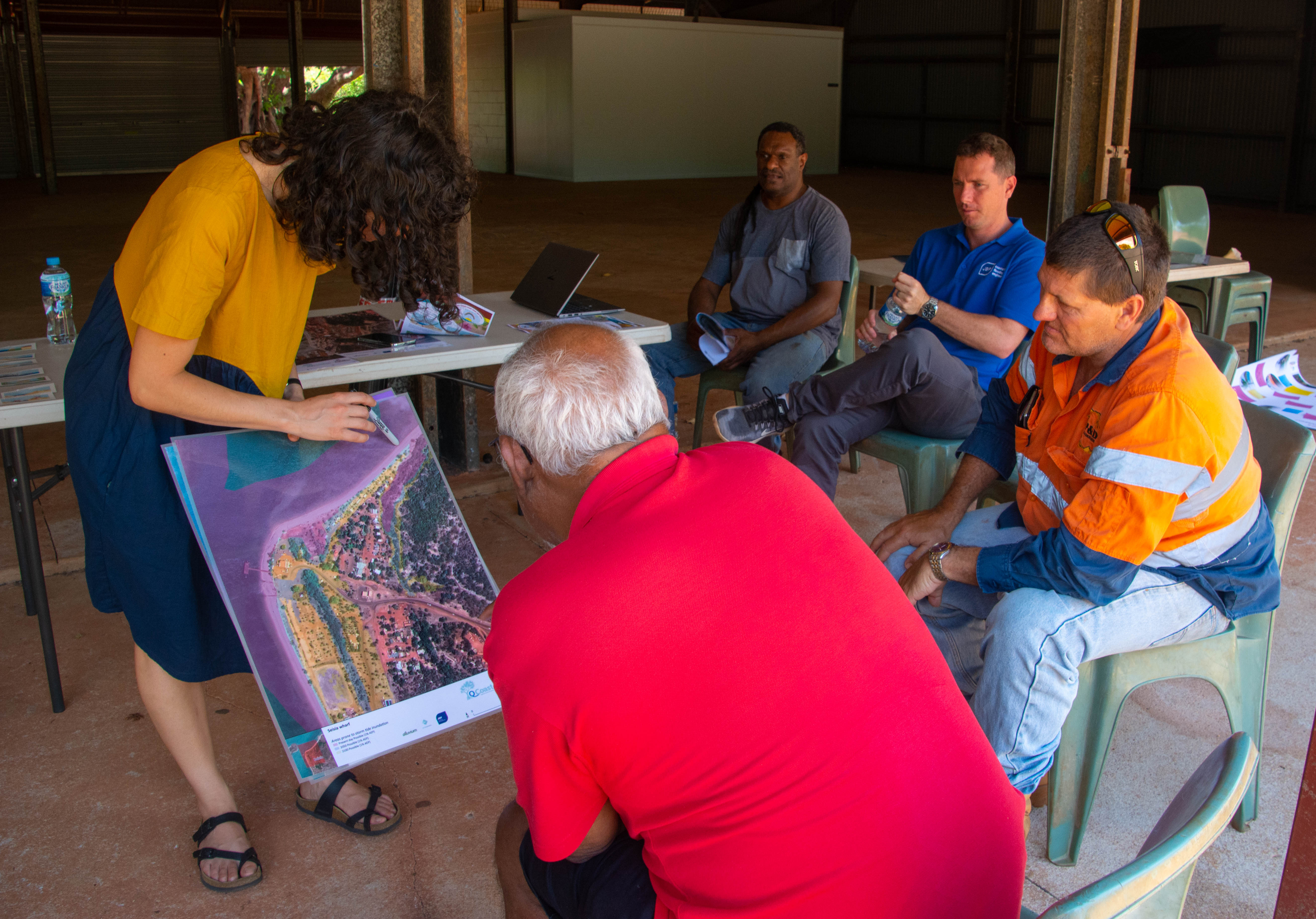 Photo of 5 participants in a consultation workshop, looking at a map.