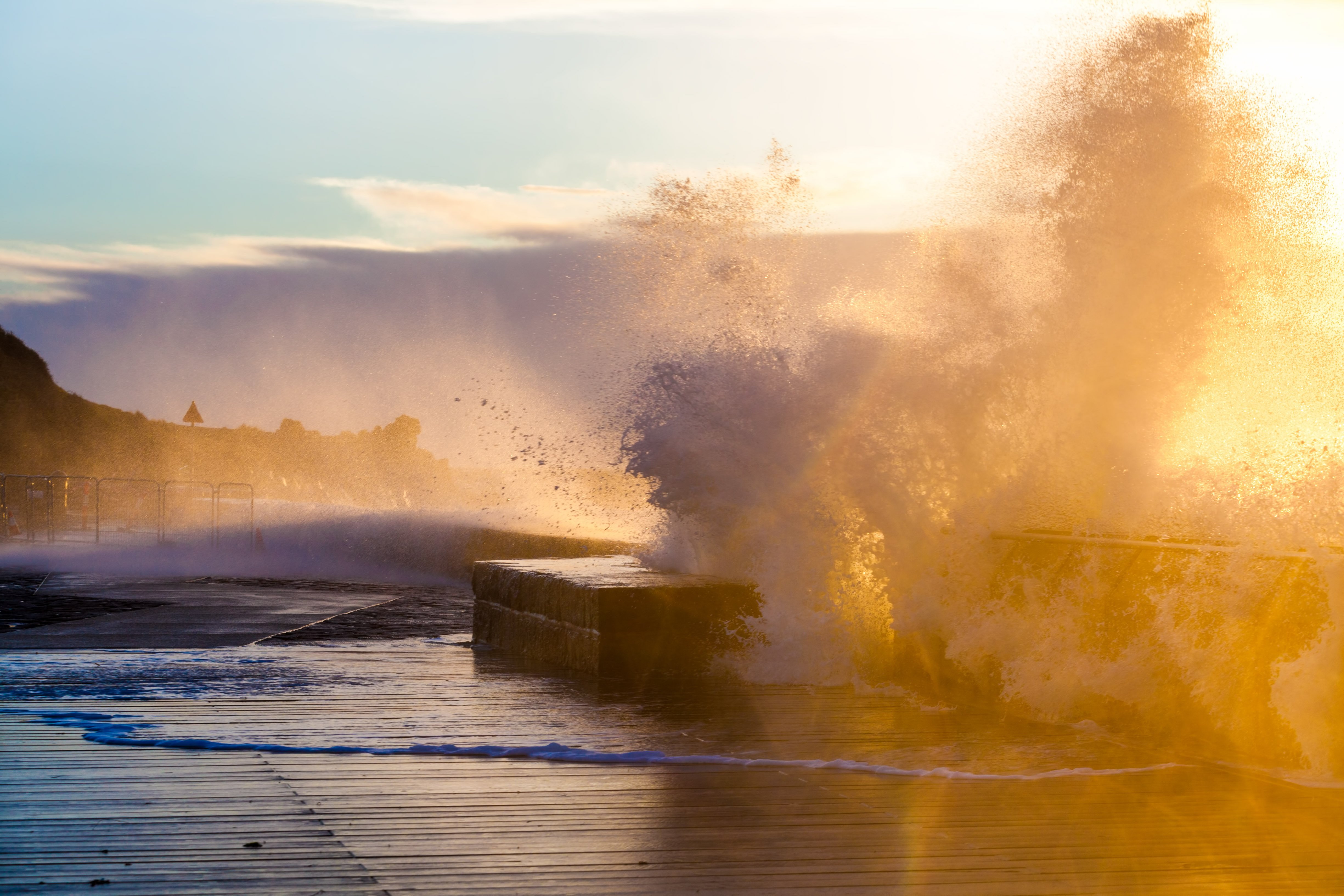 Waves crashing with force on Mornington Pier and breakwater at sunset in Melbourne, Victoria